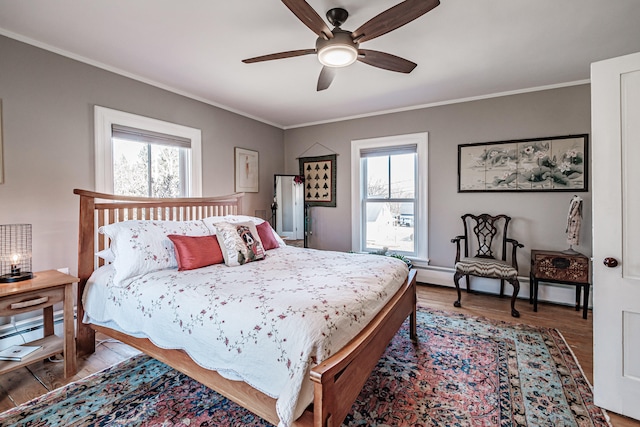 bedroom featuring multiple windows, ceiling fan, crown molding, and wood-type flooring