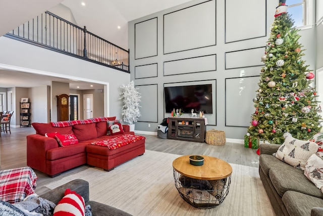 living room with light hardwood / wood-style flooring and high vaulted ceiling