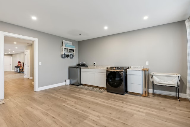 laundry room with washer / dryer and light hardwood / wood-style floors