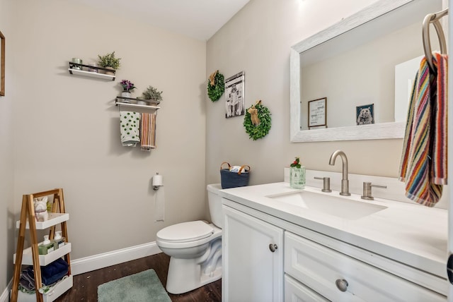 bathroom with hardwood / wood-style flooring, vanity, and toilet