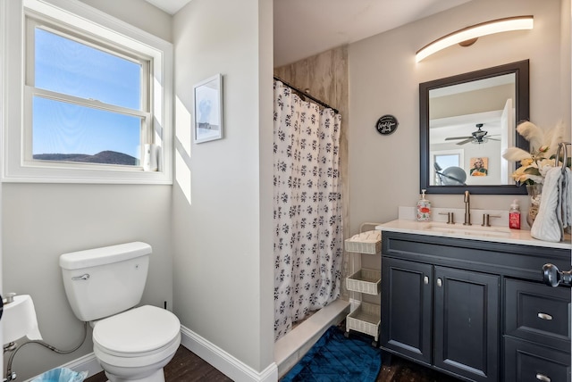 bathroom with a shower with curtain, vanity, ceiling fan, wood-type flooring, and toilet