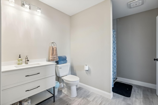 bathroom featuring toilet, vanity, and hardwood / wood-style flooring