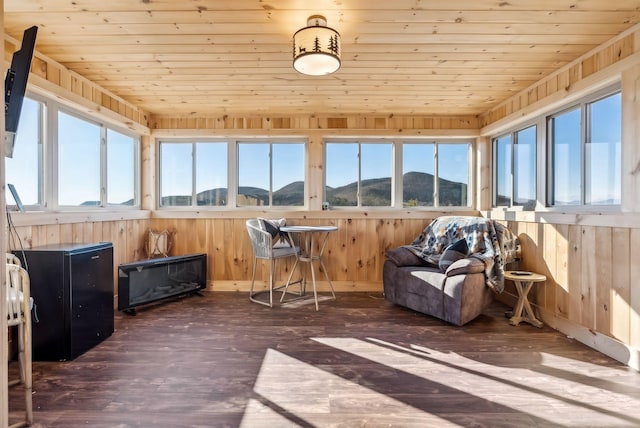 sunroom featuring a mountain view and wooden ceiling