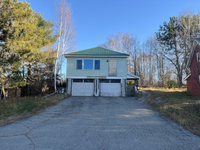 23 Hillcrest Ave, Millinocket, ME 04462 - view of side of home with asphalt driveway, metal roof, and a garage