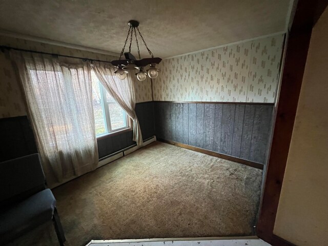 unfurnished dining area with a chandelier, carpet, a textured ceiling, and a baseboard heating unit