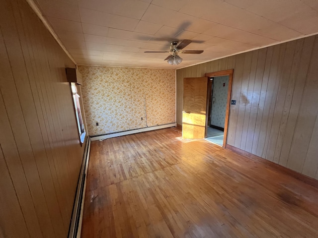 23 Hillcrest Ave, Millinocket, ME 04462 - unfurnished room featuring a ceiling fan, light wood-style flooring, baseboard heating, and wooden walls