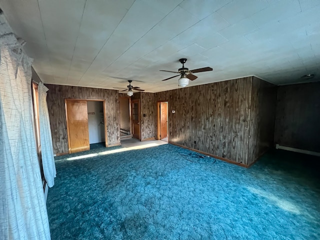 interior space featuring ceiling fan and wood walls