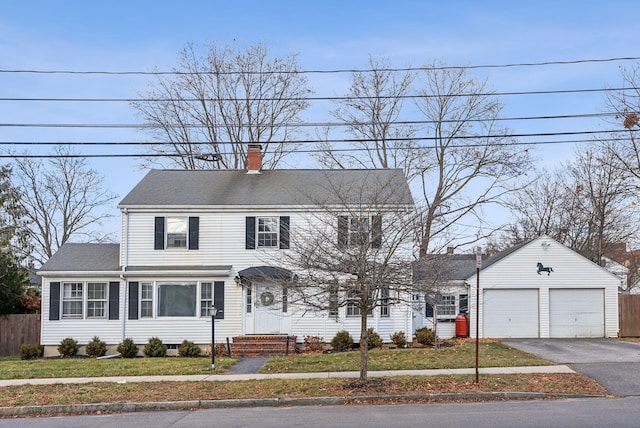 colonial inspired home with a garage and a front lawn