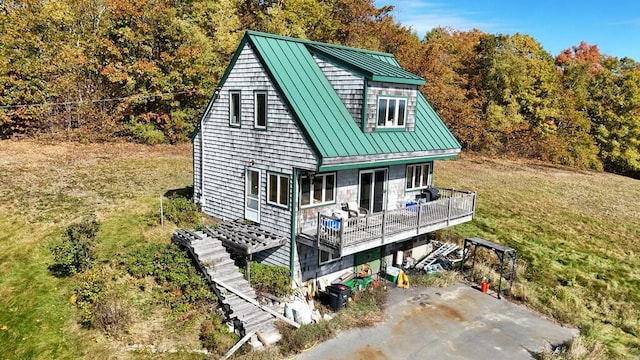 rear view of house featuring a deck and a lawn