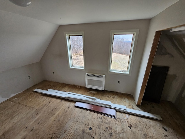 additional living space with wood-type flooring and vaulted ceiling