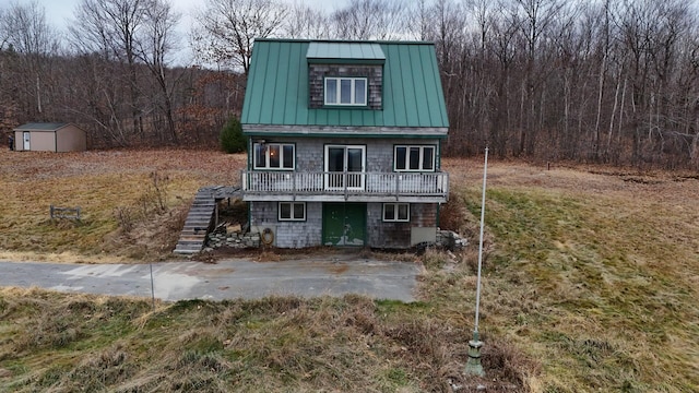 view of front facade with a storage shed and a deck