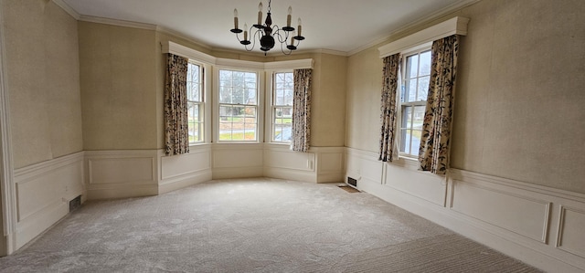 carpeted spare room with crown molding and a notable chandelier