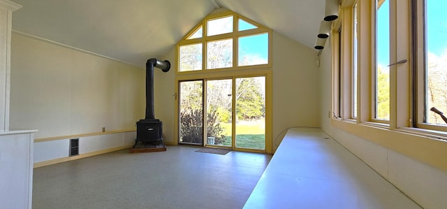 interior space featuring a wood stove and high vaulted ceiling