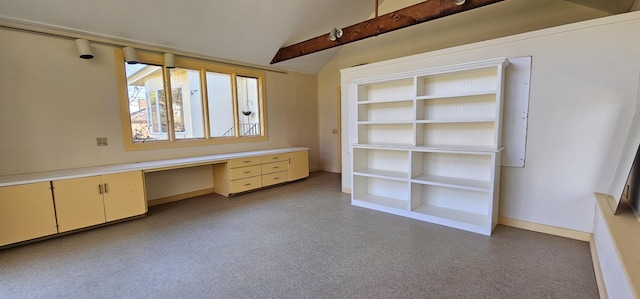 spare room featuring built in desk and lofted ceiling