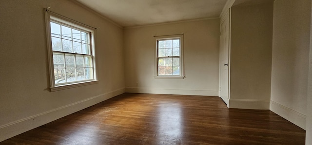 unfurnished room featuring a healthy amount of sunlight, dark hardwood / wood-style floors, and ornamental molding