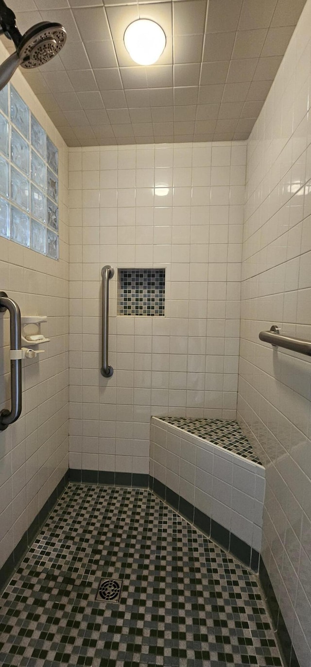 bathroom featuring a shower with door and tile walls