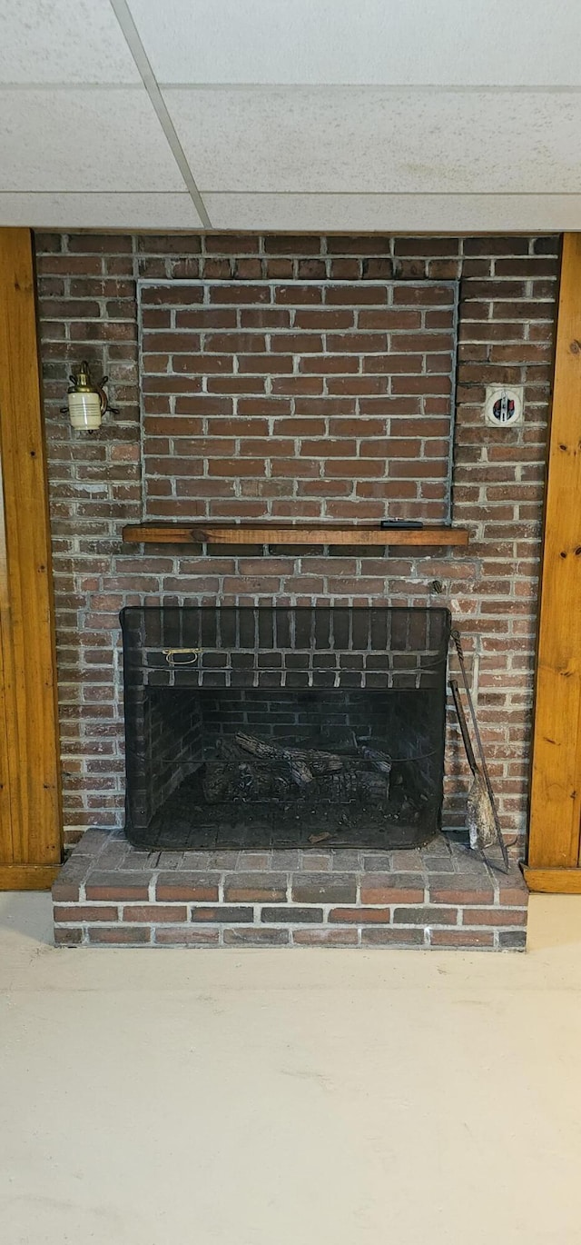 details featuring a paneled ceiling and a brick fireplace