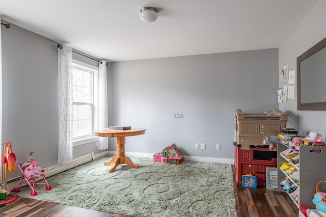 rec room featuring a baseboard radiator and dark wood-type flooring