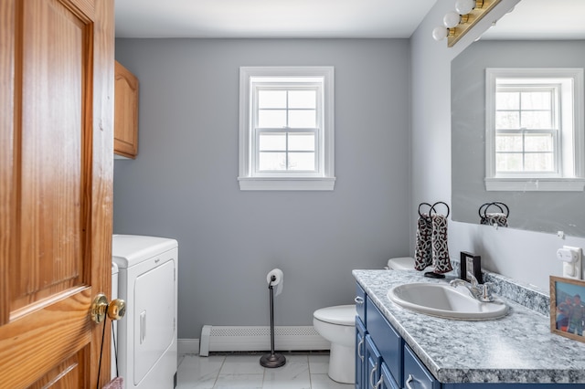 bathroom featuring baseboard heating, washing machine and dryer, a wealth of natural light, and vanity