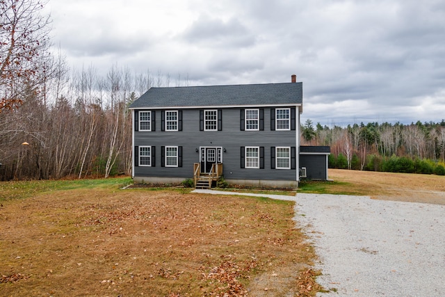 colonial home featuring a front lawn