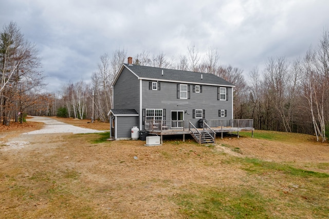 back of house featuring a wooden deck and a yard