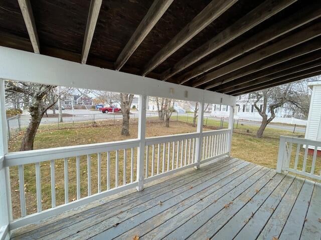 wooden deck featuring a lawn