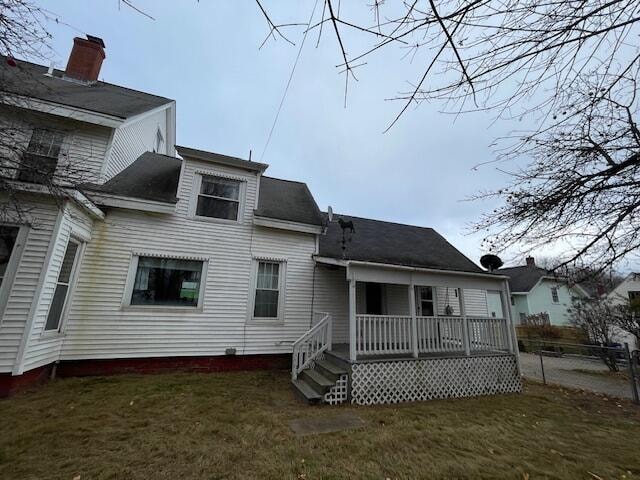 rear view of property featuring a yard