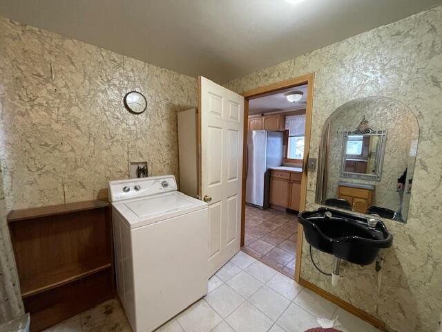 laundry area with washer / dryer and light tile patterned floors