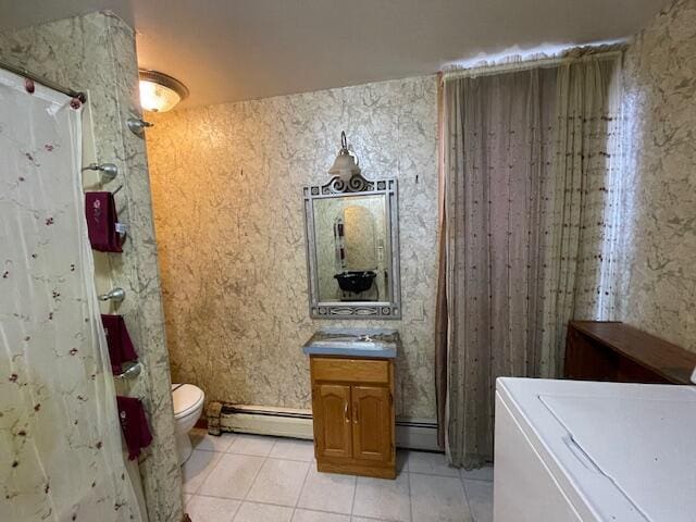 bathroom featuring washer / dryer, tile patterned flooring, a baseboard heating unit, toilet, and vanity