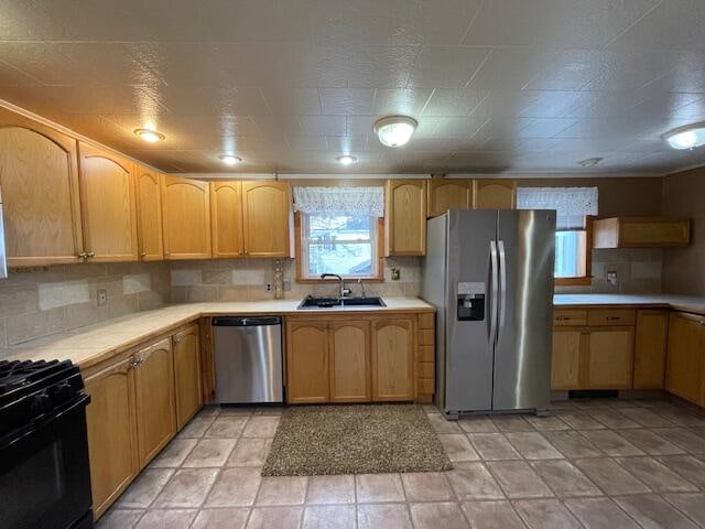 kitchen featuring backsplash, sink, stainless steel appliances, and light brown cabinets