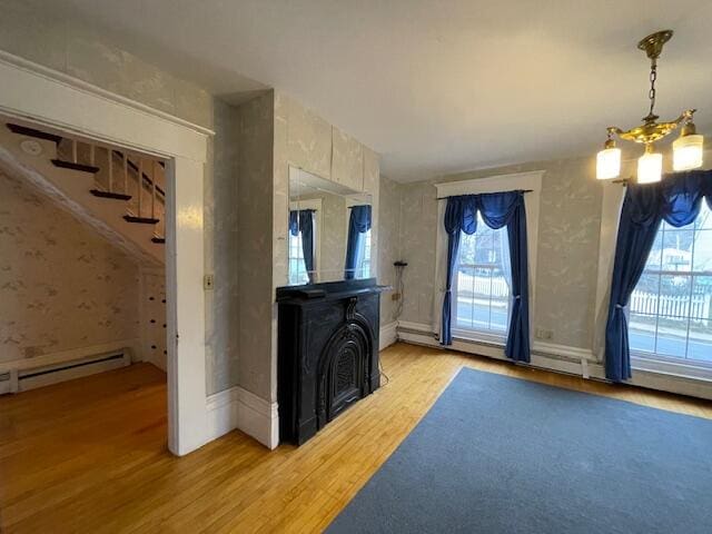 living room with a fireplace, hardwood / wood-style flooring, vaulted ceiling, and a notable chandelier