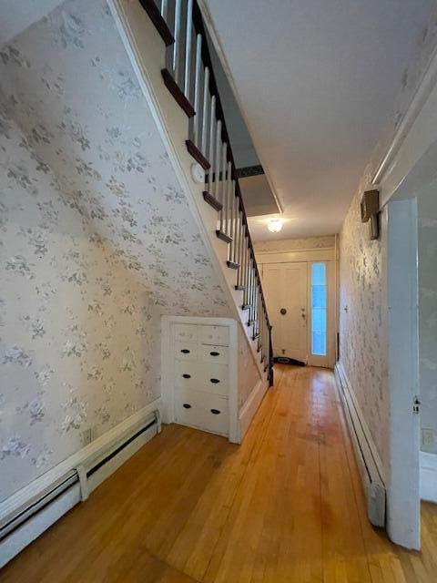 hall with light hardwood / wood-style floors and baseboard heating