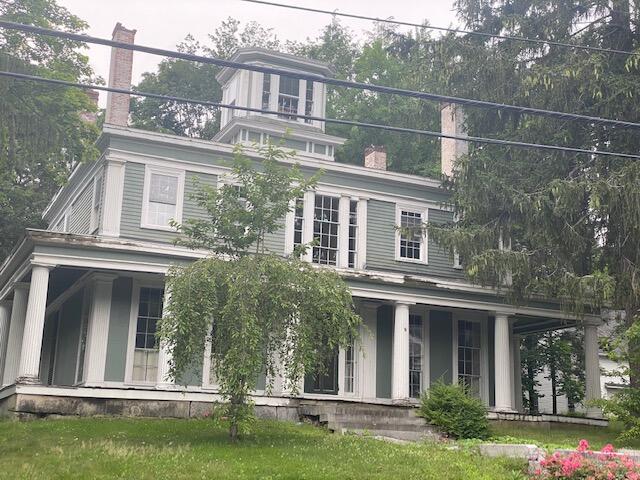 view of front of home with a porch and a front lawn