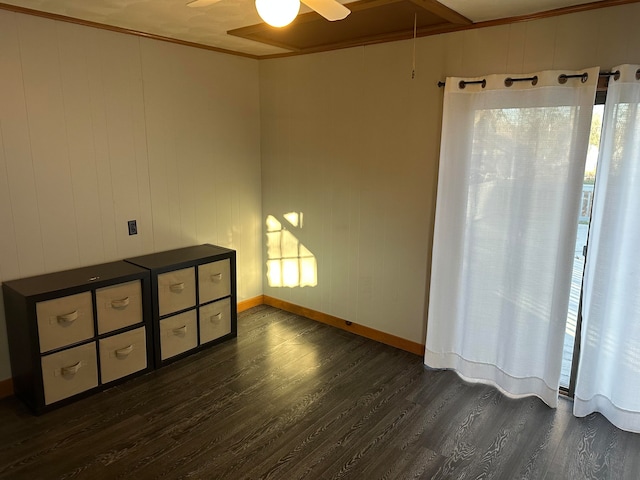 spare room with crown molding, ceiling fan, and dark wood-type flooring