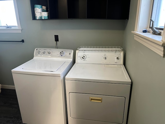 laundry area with separate washer and dryer, plenty of natural light, cabinets, and dark hardwood / wood-style floors