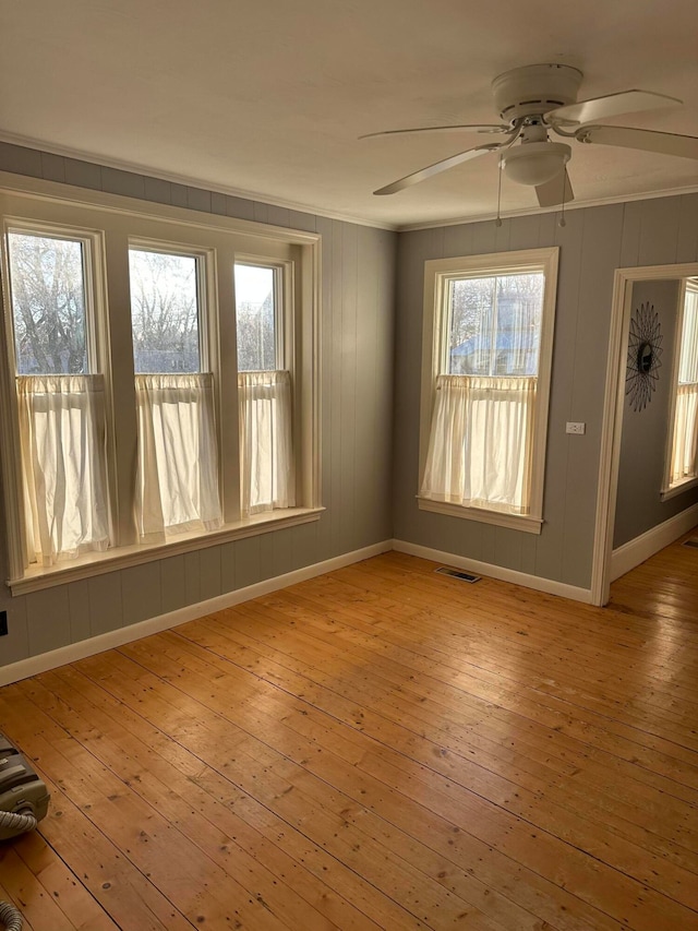 unfurnished room featuring light hardwood / wood-style flooring, ceiling fan, and ornamental molding