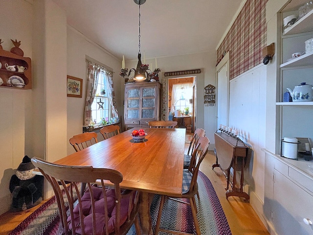 dining room with a chandelier, light hardwood / wood-style floors, and ornamental molding