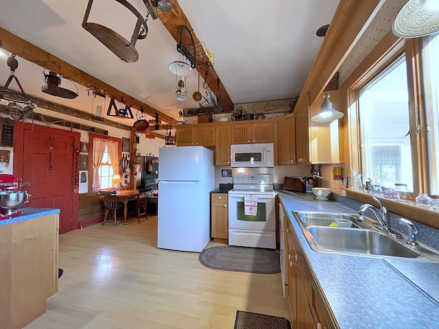 kitchen featuring a wealth of natural light, sink, decorative light fixtures, and white appliances