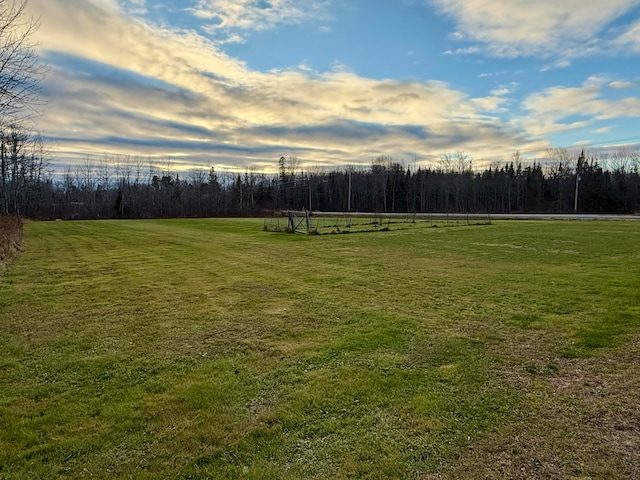 yard at dusk featuring a rural view