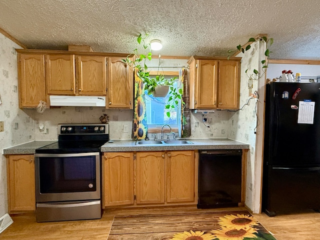 kitchen with black appliances, light hardwood / wood-style floors, sink, and a textured ceiling