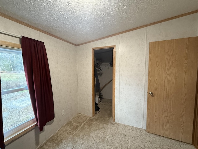 526 Darling Rd, Hudson, ME 04449 - unfurnished bedroom featuring ornamental molding, a textured ceiling, carpet, a walk in closet, and a closet