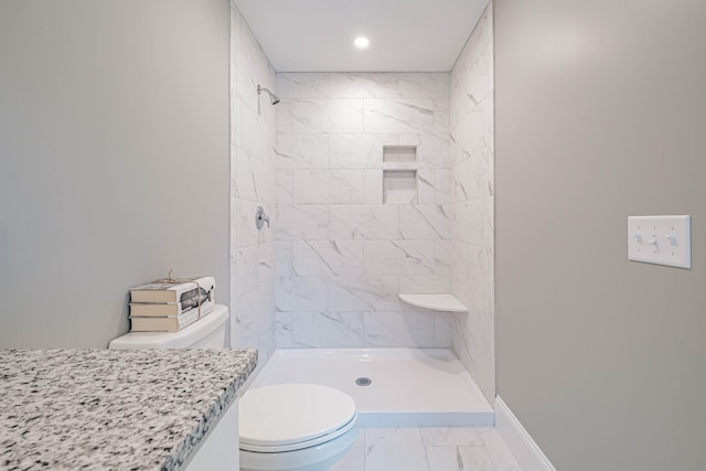 bathroom with toilet and tiled shower