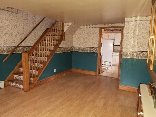 bonus room with wood-type flooring and baseboard heating