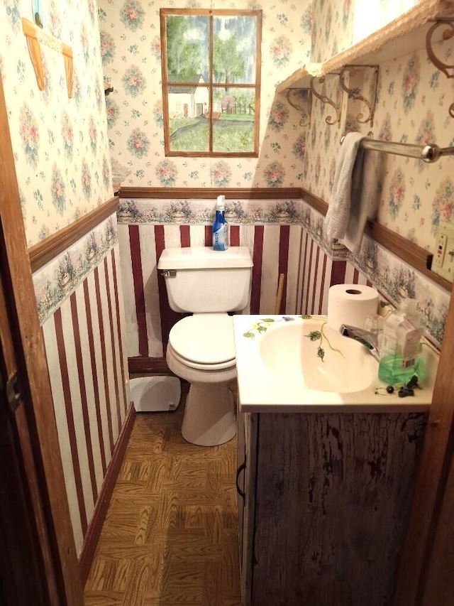 bathroom featuring vanity, toilet, and parquet floors