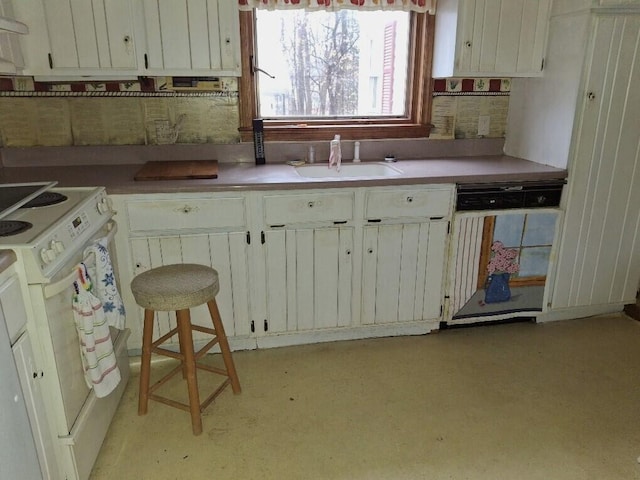 kitchen with white appliances, exhaust hood, sink, white cabinets, and a breakfast bar area