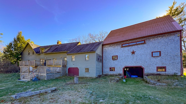 rear view of property with a lawn and a deck