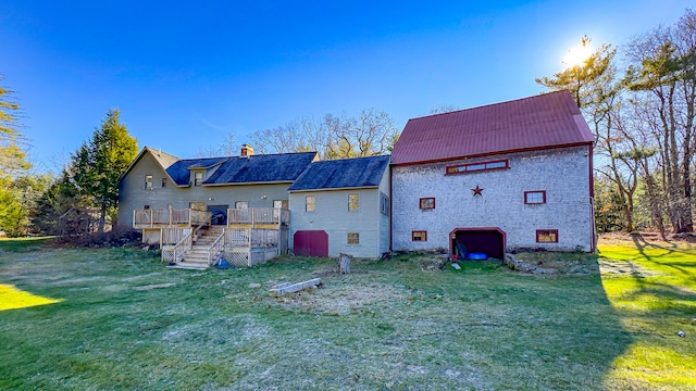 back of house with a wooden deck and a yard