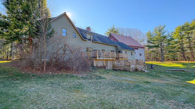 back of house with a deck and a lawn