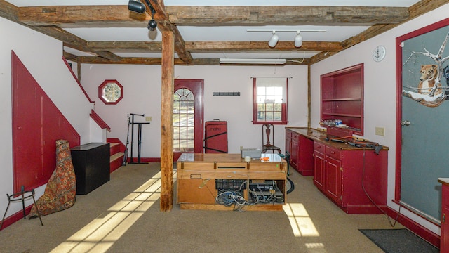 carpeted office space featuring beamed ceiling