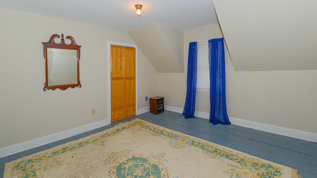 additional living space with lofted ceiling and hardwood / wood-style flooring